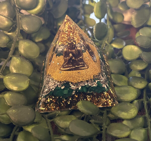 Cette orgonite pyramidale bouddhiste de guérison et de tendresse vous fait honneur avec son Bouddha. Ses feuilles d'or en appellent à une transformation