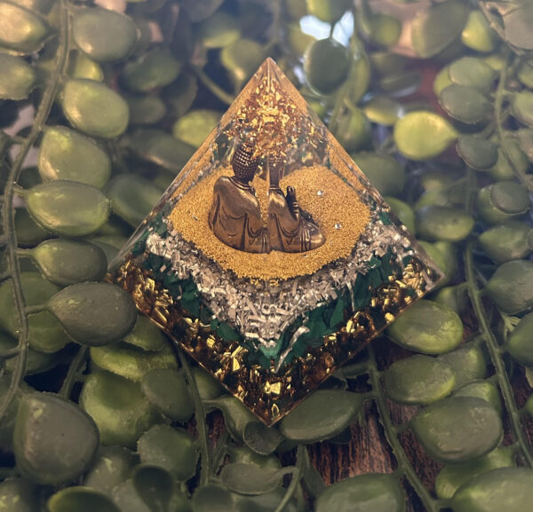 Cette orgonite pyramidale bouddhiste de guérison et de tendresse vous fait honneur avec son Bouddha. Ses feuilles d'or en appellent à une transformation